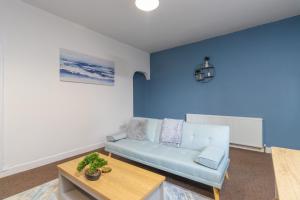 a blue living room with a couch and a table at HIGH STREET APARTMENT, SLEEPS 6 GUESTs! in Bedworth +2 photos