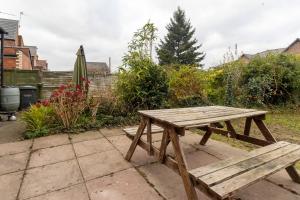 a wooden picnic table sitting on a patio at HIGH STREET APARTMENT, SLEEPS 6 GUESTs! in Bedworth