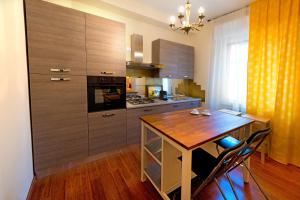 ヴェローナにあるVerona Centre Apartmentsのウッドフロアのキッチン(木製テーブル付)