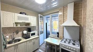 une cuisine avec un évier et une cuisinière four supérieur dans l'établissement Abay street- Tashkent city center, à Tachkent