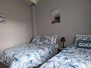 ein Schlafzimmer mit 2 Betten und einer Lampe in der Unterkunft The Starfish Cottage in Scottburgh + 15 Fotos