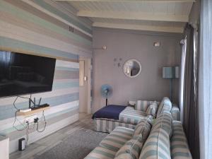 ein Wohnzimmer mit Couch und Flachbildfernseher in der Unterkunft The Starfish Cottage in Scottburgh