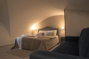 a bedroom with a bed and a couch at Lume Guest House in Catania