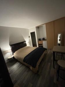 a bedroom with a large bed and a table at Chez Melody in Pugnac