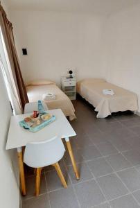 Zimmer mit 2 Betten, einem Tisch und einem Bett in der Unterkunft La Fueguina Departamento 2 en Gobernador Gregores in Gobernador Gregores