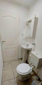 ein weißes Badezimmer mit Toilette und Waschbecken in der Unterkunft La Fueguina Departamento 2 en Gobernador Gregores in Gobernador Gregores