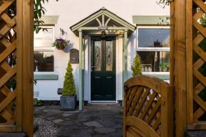 a green door on a white house with a bench at Shrimpers Cottage in Lytham St Annes