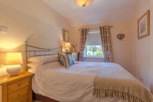 a bedroom with a large bed and a window at Shrimpers Cottage in Lytham St Annes