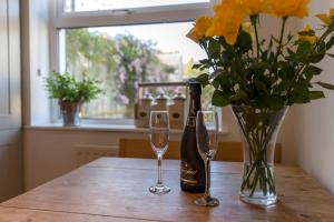 a table with a bottle of wine and two glasses at Shrimpers Cottage in Lytham St Annes +7 photos