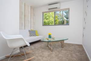 a living room with a white couch and a table at 10 Hastings Street Motel in Noosa Heads