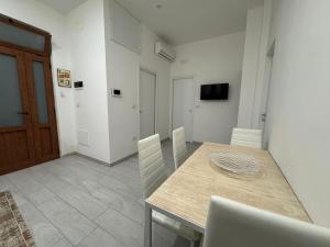 a dining room with a wooden table and chairs at desHouse in Molfetta +4 photos