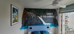 a room with a wall with a painting on the wall at Le 5ème étage du bonheur in Pointe-à-Pitre