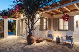 a patio with two chairs and a tree in a large vase at Seaduction in Kastraki Naxou +27 photos