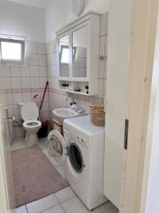 Un baño con lavadora y un inodoro. en Emerald Bay, en Yenimahalle