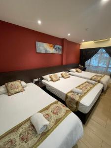 a hotel room with three beds in a room at Mizie Hotel Kuala Lumpur in Kuala Lumpur
