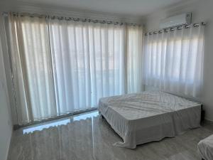 a bedroom with a bed and a large window at Suites Fazenda Muriqui in Vila Muriqui +38 photos