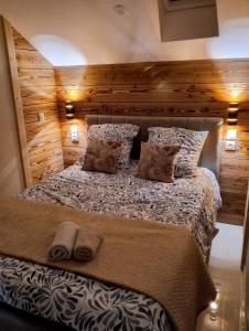 a bedroom with a bed with a wooden wall at Résidence Mirage avec vidéo surveillance in Albertville