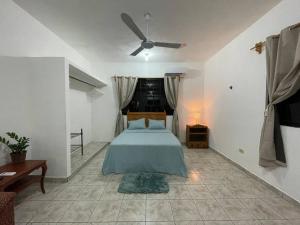 a bedroom with a bed and a ceiling fan at Casa Juan, Estudio en Cozumel in Cozumel