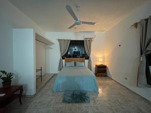 a bedroom with a bed with a ceiling fan at Casa Juan, Estudio en Cozumel in Cozumel