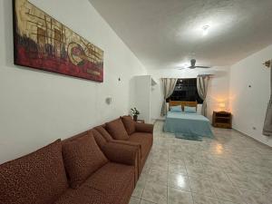 a living room with a couch and a bed at Casa Juan, Estudio en Cozumel in Cozumel