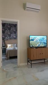 a living room with a flat screen tv and a bed at Sherryflat Catedral in Jerez de la Frontera