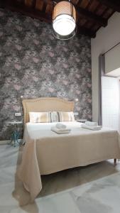 a bedroom with a large bed with a floral wall at Sherryflat Catedral in Jerez de la Frontera