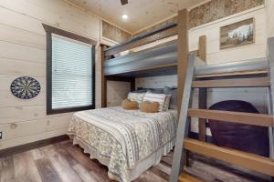 a bedroom with two bunk beds and a window at Hideaway Pointe in Sevierville