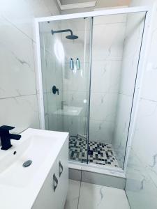 a bathroom with a shower with a glass door at Stay-Tiah Whyte Room in Durban