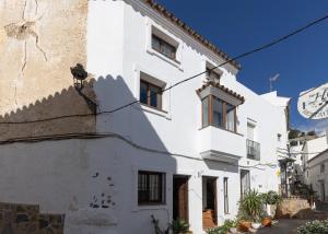 a white building with a cat on the side of it at Apartament Ewa z widokiem Casares in Casares