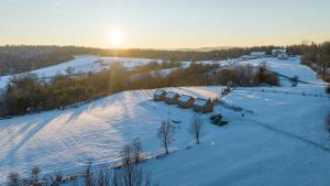 eine Luftansicht eines schneebedeckten Feldes mit Sonnenuntergang in der Unterkunft Widokowe Stodoły Bieszczady - domy z panoramą połonin in Lesko