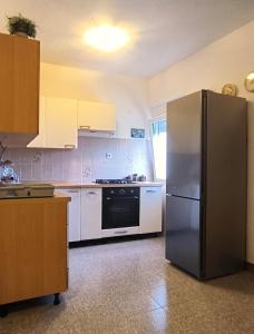 a kitchen with a stainless steel refrigerator and white cabinets at Apartments Elena Green Island Escape in Ugljan +30 photos