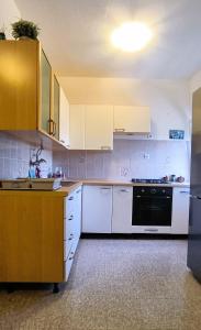 a kitchen with white cabinets and a black oven at Apartments Elena in Ugljan +55 photos