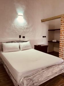布加Casa Encanto Buga的砖墙房间内的一张白色床