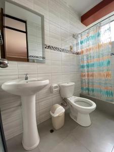un bagno bianco con lavandino e WC di Casa Hospedaje Inkani a La Merced