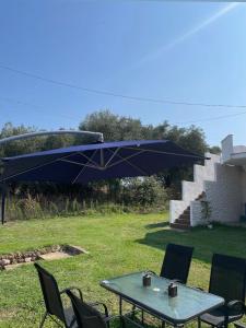 a table and chairs with a blue umbrella at Luxury Villa Vista in Tsouknída