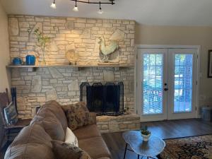 a living room with a couch and a stone fireplace at Hidden Haven in Canyon Lake
