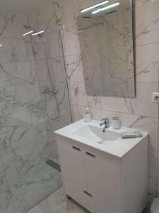 a bathroom with a sink and a shower with a mirror at Casa Algar - La Calma - big terrace - 4 pools in Playa Flamenca
