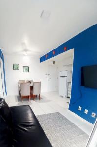 a living room with a couch and a blue wall at Apto Vista do Pôr do Sol SUN7 in Ilhéus