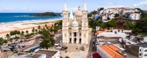a large building with a beach in the background at Apto Vista do Pôr do Sol SUN7 in Ilhéus