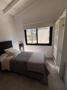 a bedroom with a large bed and a window at Sierras VGB Centro in Villa General Belgrano