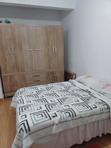 a bedroom with a bed and wooden cabinets at Seu descanso merecido está aqui in São Sebastião