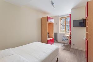 Un dormitorio con una cama blanca y un escritorio. en Chambres centre-ville avec espaces partagés - accessibles et abordables, en Nantes