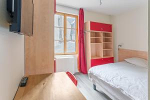 Un dormitorio con una cama y una mesa y una ventana. en Chambres centre-ville avec espaces partagés - accessibles et abordables, en Nantes