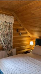 a bedroom with a bed and a wooden wall at Cottage Lavanda окремий котедж з каміном in Bukovel +150 photos