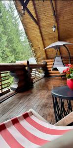 una terrazza con amaca e sedia sul portico di Cottage Lavanda окремий котедж з каміном a Bukovel