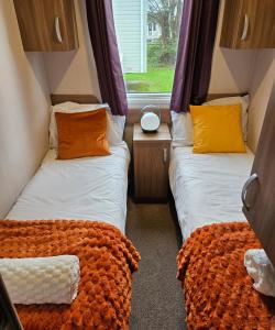 two beds in a small room with a window at Holiday Home at Combe Haven, St Leonards, Hastings in St. Leonards +7 photos
