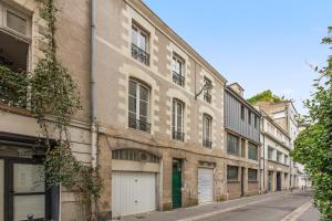 un antiguo edificio con un garaje en una calle en Chambres centre-ville avec espaces partagés - accessibles et abordables, en Nantes