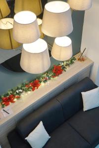 a table with three lights and flowers on it at Lume Guest House in Catania