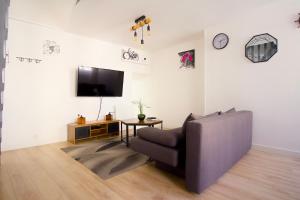 a living room with a couch and a flat screen tv at Triplex Lumineux à Cherbourg, hyper centre, 2 pas du Port & Vie Nocturne, Intendance Luxury Host in Cherbourg en Cotentin