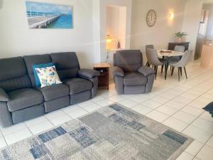 un salon avec un canapé, des chaises et une table dans l'établissement Marina Views On Melton 107-3 Melton Terrace, Townsville, à Townsville